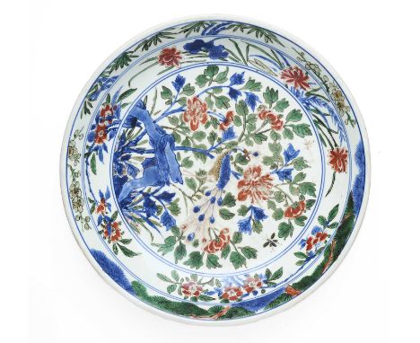 A CHINESE FAMILLE-VERTE 'PEACOCK' DISH, QING DYNASTY, KANGXI PERIOD the rounded sides rising from a short tapering foot to an