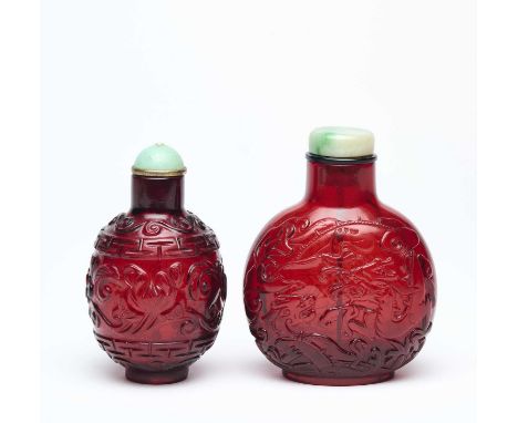 TWO CHINESE CARVED TRANSPARENT RUBY-RED GLASS SNUFF BOTTLES  comprising: a flattened globular bottle carved to each face with
