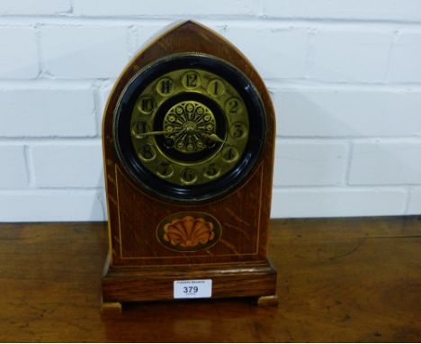 An oak domed top mantle clock with an inlaid paterea to front, with a gilt brass chapter ring with Arabic numerals