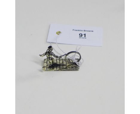 A novelty silver figure, modelled playing with a hoop, stamped 925, 4cm long 