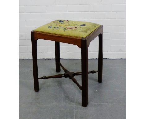 A mahogany stool with a rectangular tapestry top on square block supports, with a turned undertier, 52 x 46cm
