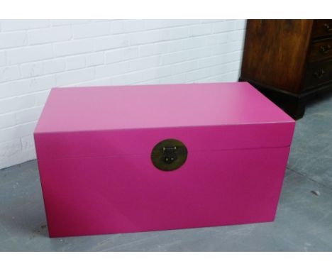 A contemporary painted pink storage trunk with brass handles to side and brass work clasp to front, 45 x 98m