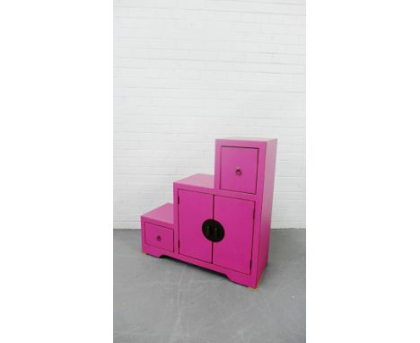 A contemporary pink painted cabinet of stepped form with an arrangement of cupboard doors on bracket support, 91 x 91cm 
