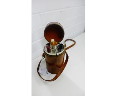 A vintage silver plated triple decanter and shot glass set, contained in a circular brown leather carry case