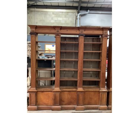 A pair of mid 20th century Sheraton style pitch pine and ply open bookcases, the adjustable shelves divided by fluted Ionic c