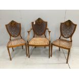A set of three Edwardian Sheraton Revival painted satinwood caned chairs, one with arms***