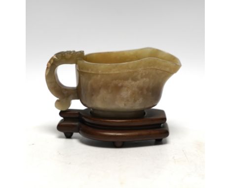 An 18th century Chinese archaistic jade pouring vessel, yi, with carved dragon handle, 6cm high, on a hardwood stand***CONDIT
