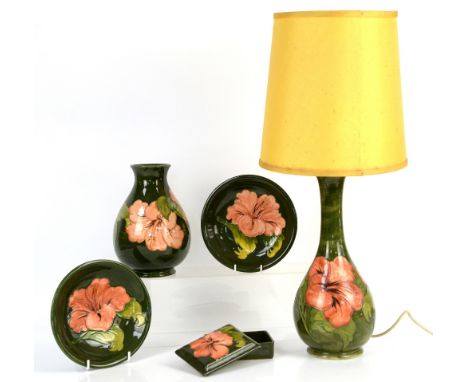 Moorcroft Hibiscus pattern with pink flowers on green ground, to include a table lamp with impressed marks and paper label, h