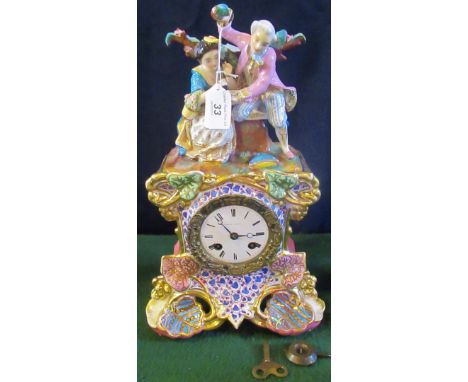 A 19th century profusely decorated French mantle clock surmounted with romantic figures over gilt and floral decoration, bear
