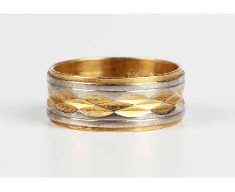 An 18ct two colour gold wide band wedding ring with banded and faceted decoration, Birmingham 1965, weight 4.7g, ring size ap