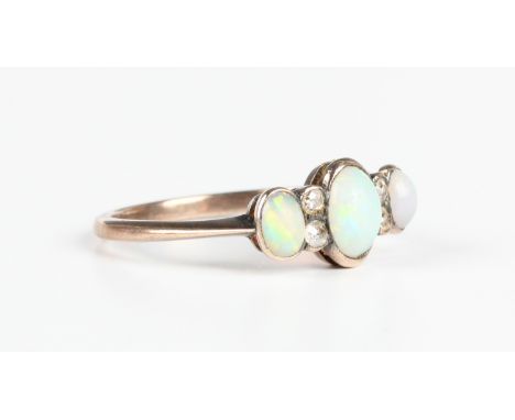 A gold, opal and diamond ring, mounted with three oval opals alternating with two pairs of cushion cut diamonds, unmarked, we