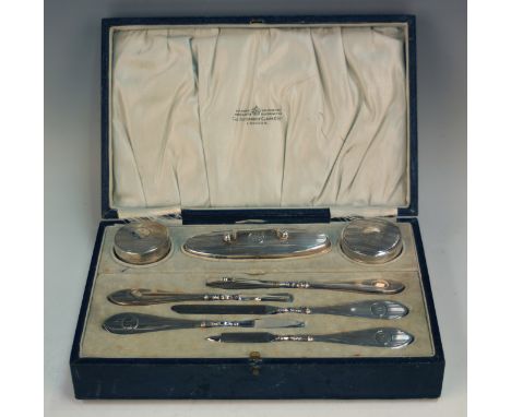 A George V silver part manicure set, comprising two circular pots and covers, nail buffer and five silver handled nail implem