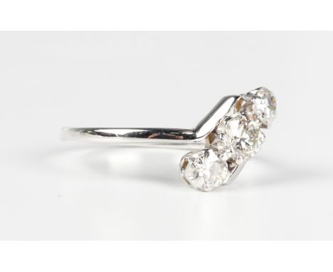 A white gold and diamond three stone ring in a twist design, mounted with a graduated row of circular cut diamonds, detailed 