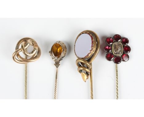 A Georgian flat cut almandine garnet set mourning stickpin, glazed to the centre with a hair locket compartment, width of fin