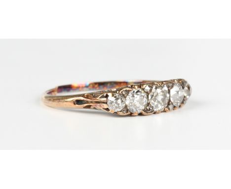 A gold and diamond five stone ring, mounted with a row of cushion cut diamonds with four pairs of rose cut diamonds at interv