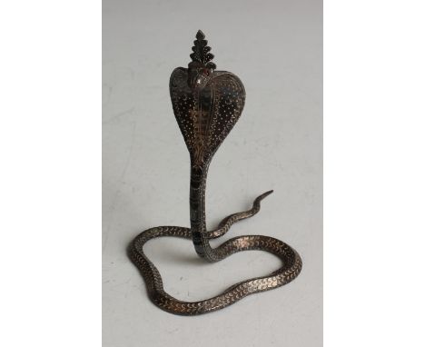 An Indian model of a silver cobra with garnet set eyes and engraved decoration, modelled in a coiled pose with head raised, w