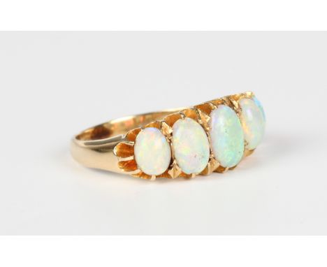 A gold and opal five stone ring, circa 1900, claw set with a row of graduated oval opals, detailed '18', weight 4g, ring size