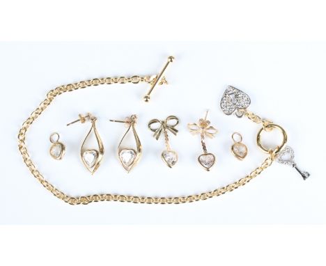 A 9ct gold oval link bracelet, fitted with two colourless gem set charms, comprising a key and a padlock, on a T-bar and ring