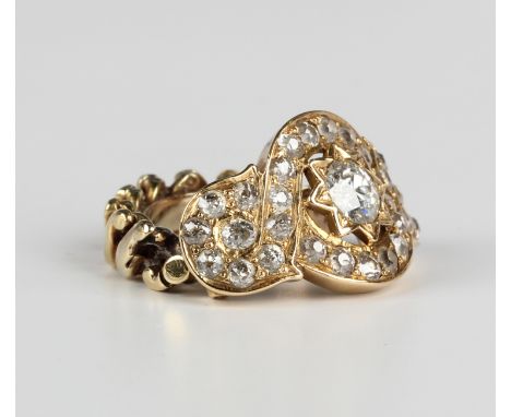 A gold and diamond ring, mounted with the principal Old European cut diamond in a star shaped setting, otherwise in a wide sc