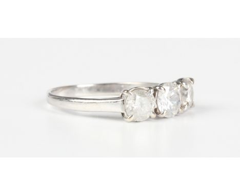 A white gold and diamond three stone ring, claw set with a row of circular cut diamonds, indistinct mark, weight 2.5g, total 