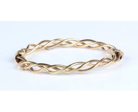 A gold oval hinged bangle in a twist design, on a snap clasp, detailed '375', weight 11.4g, inside width 6cm.Buyer’s Premium 