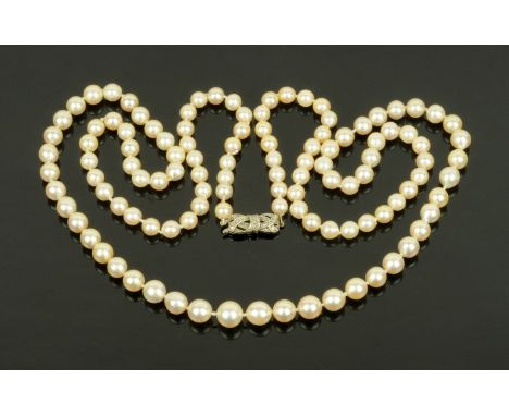 A single string of pearls, united by a 9 ct white gold bow shaped clasp, diameters 6 mm - 9 mm.  Length 46 cm.  