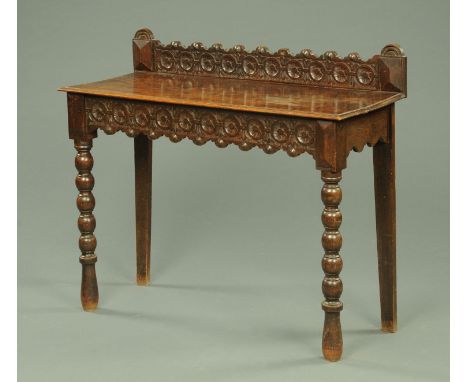 A late Victorian oak side table, with rear up stand, raised on bobbin turned legs, width 107 cm.