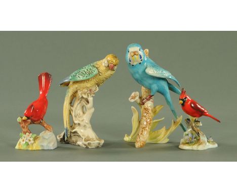 A Goebel figure of a budgerigar, modelled upon flowering stem, two porcelain figures of red cardinals and a further figure of