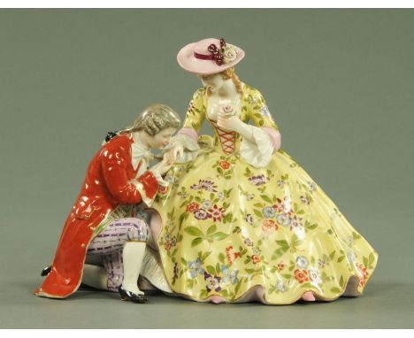 A Furstenberg type porcelain figure group, early 20th century, modelled as a gentleman and lady in 19th century dress, the ge