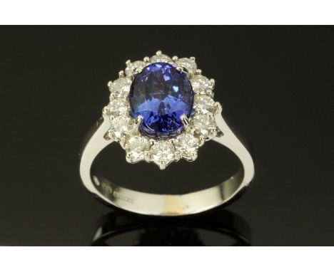 An 18 ct white gold oval tanzanite and round brilliant cut diamond cluster ring, size M, tanzanite +/- 2.43 carats, diamonds 