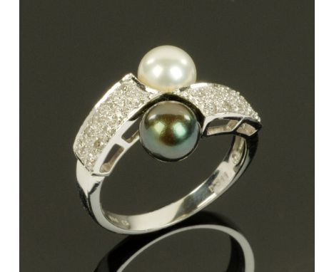 A 14 ct white gold pearl and diamond set ring, with one black and one white pearl, size O.