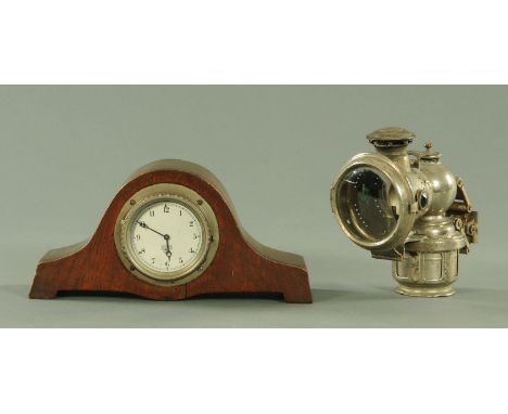 A vintage Smiths car clock, number P-359.812, now mounted in a clock case and a Lucas carbide motorcycle lamp.