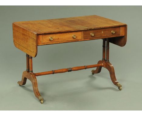 A Regency mahogany sofa table, ebony strung, fitted with two frieze drawers with brass knob handles and raised on turned end 