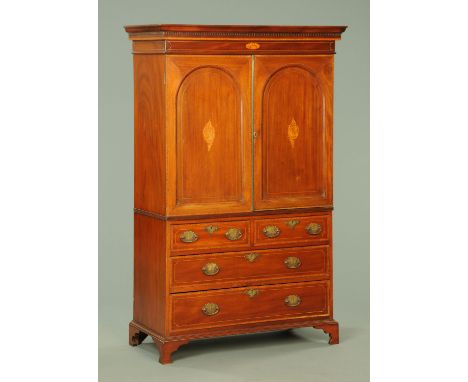 An Edwardian inlaid mahogany gentleman's wardrobe, with moulded dentil cornice above a pair of doors enclosing pullout trays,