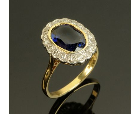 An 18 ct gold sapphire and diamond ring, with oval sapphire surrounded by +/- 1 carat of diamonds, size R (see illustration).