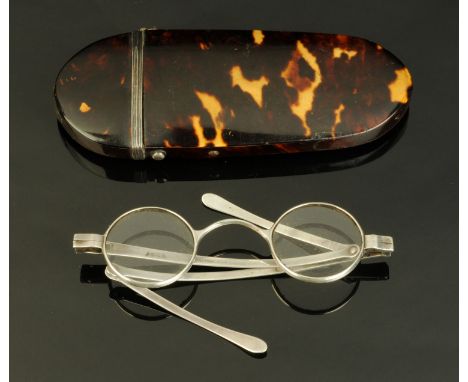 An early 19th century tortoiseshell spectacle case, containing a pair of silver hallmarked folding spectacles. CONDITION REPO