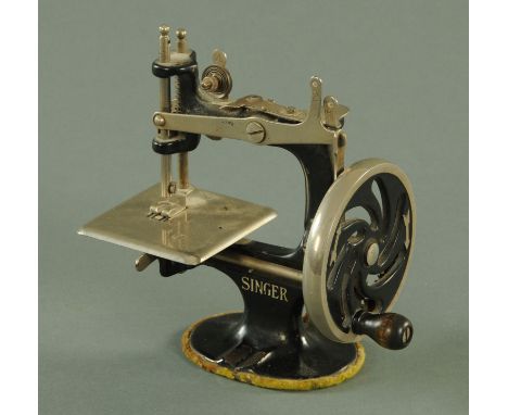 Singer Manufacturing Co, a miniature cast iron manual sewing machine, early 20th century, with silver printed marks, height 1