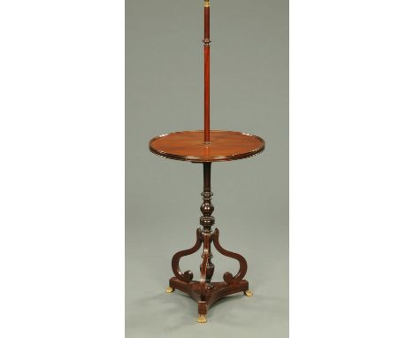 A mahogany lamp table, with circular table top, turned column and triform base terminating in metal paw feet.  