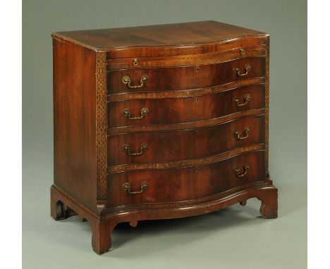 A George III style mahogany chest of drawers, circa 1950, with serpentine front, fitted with a slide and four drawers flanked