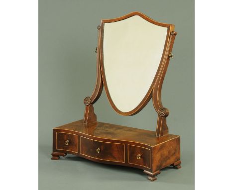 A George III style mahogany dressing table mirror, with shield shaped mirror frame and serpentine front fitted with three dra