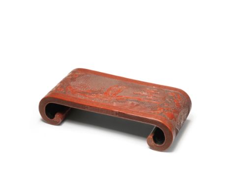 AN UNUSUAL CINNABAR LACQUER CARVED SCROLL-SHAPED STAND18th/19th centuryCarved on the top with the bearded Zhong Kui leading h
