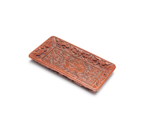 A RARE CINNABAR LACQUER CARVED 'DRAGON' TRAY16th/17th centuryThe well of the rectangular tray carved through layers of cinnab