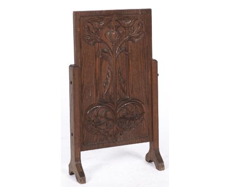 An Arts and Crafts oak firescreen, c1910, the rectangular panel carved with seedpod, flowers and entrelac between pegged upri