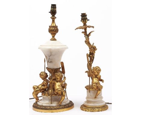 A giltmetal mounted turned alabaster table lamp, with the figures of three seated putti, each bearing a different emblem, lat