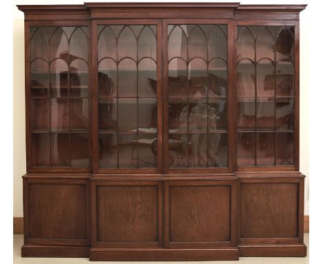 A George III mahogany breakfront library bookcase, c1800, the upper part with cavetto cornice and fitted with adjustable shel