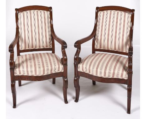 A pair of French mahogany armchairs, 19th c, the over-scrolled arms terminating in lappets, on s-scroll uprights, having serp