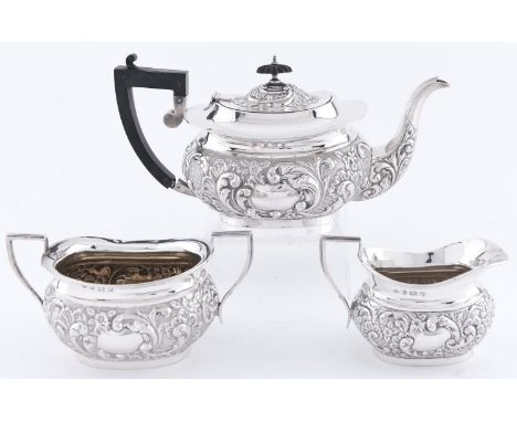 An Edward VII silver tea service, embossed with a wide band of c-scrolls, flowers and trellis, teapot 14cm h, by S Glass, Bir