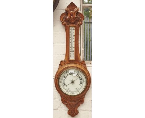 An Edwardian carved oak aneroid barometer, c1900, with mercury thermometer, 87cm h 