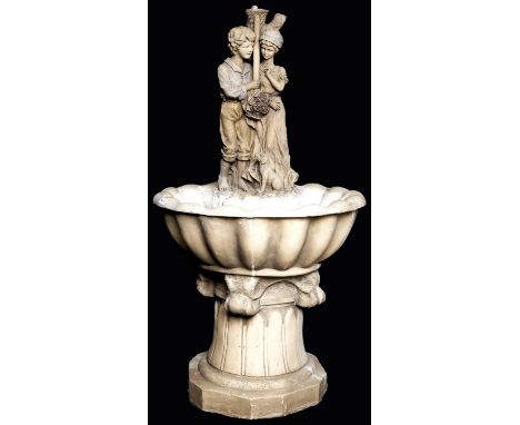 A marble effect resin fountain in the form of a youth and girl with their dog set in the centre of a shell shaped basin, late