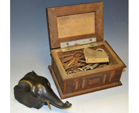 An unusual 19th Century ebonised inkwell in the form of an elephant mask, glass eyes original porcelain liner; early 20th Cen